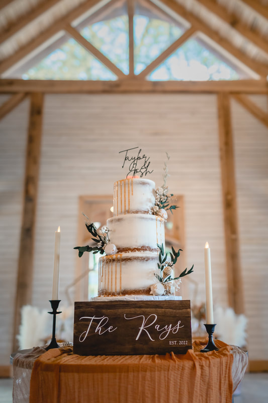 Three-tier wedding cake with custom topper and candles