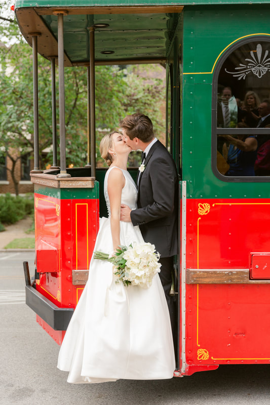 Bride and groom kissing on trolley