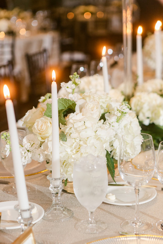 White taper candles with white roses and hydrangeas centerpieces