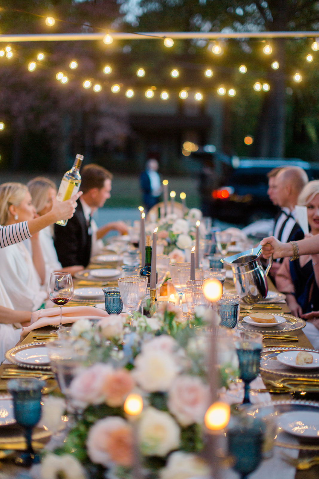 Intimate, outdoor, candlelit dinner under string lights at private residence
